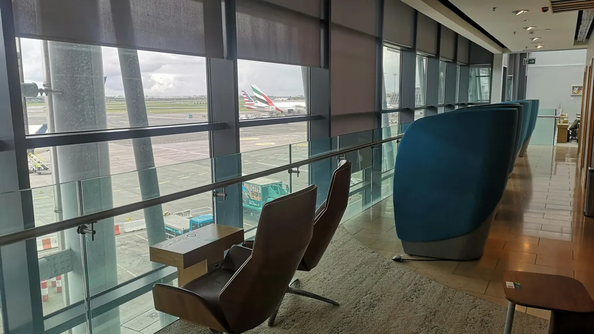 Airport lounge with tall windows looking onto parked aircraft